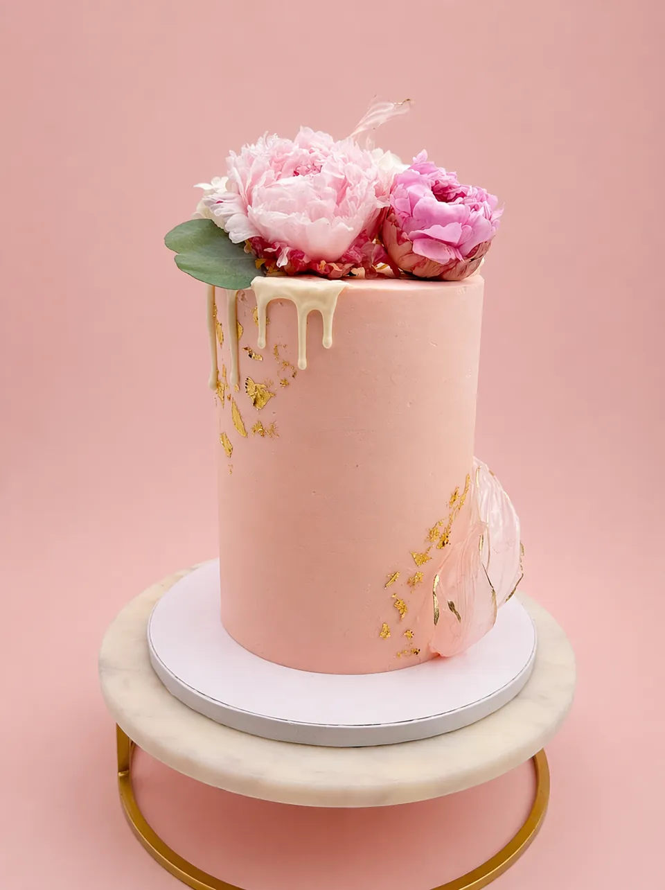 Tall blush floral drip cake with pink peonies and gold leaf