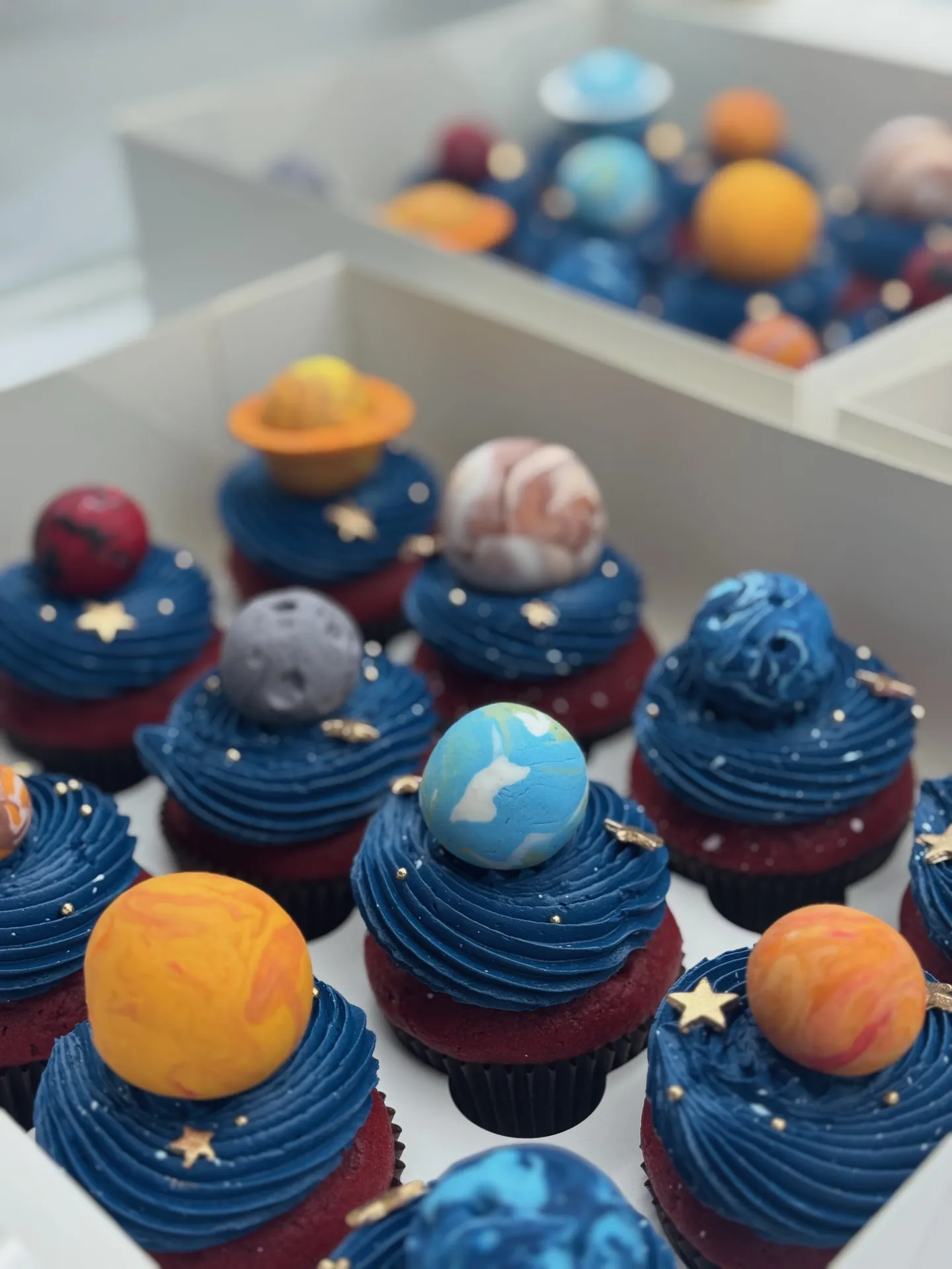 Navy space-themed event cupcakes with colorful planet decorations