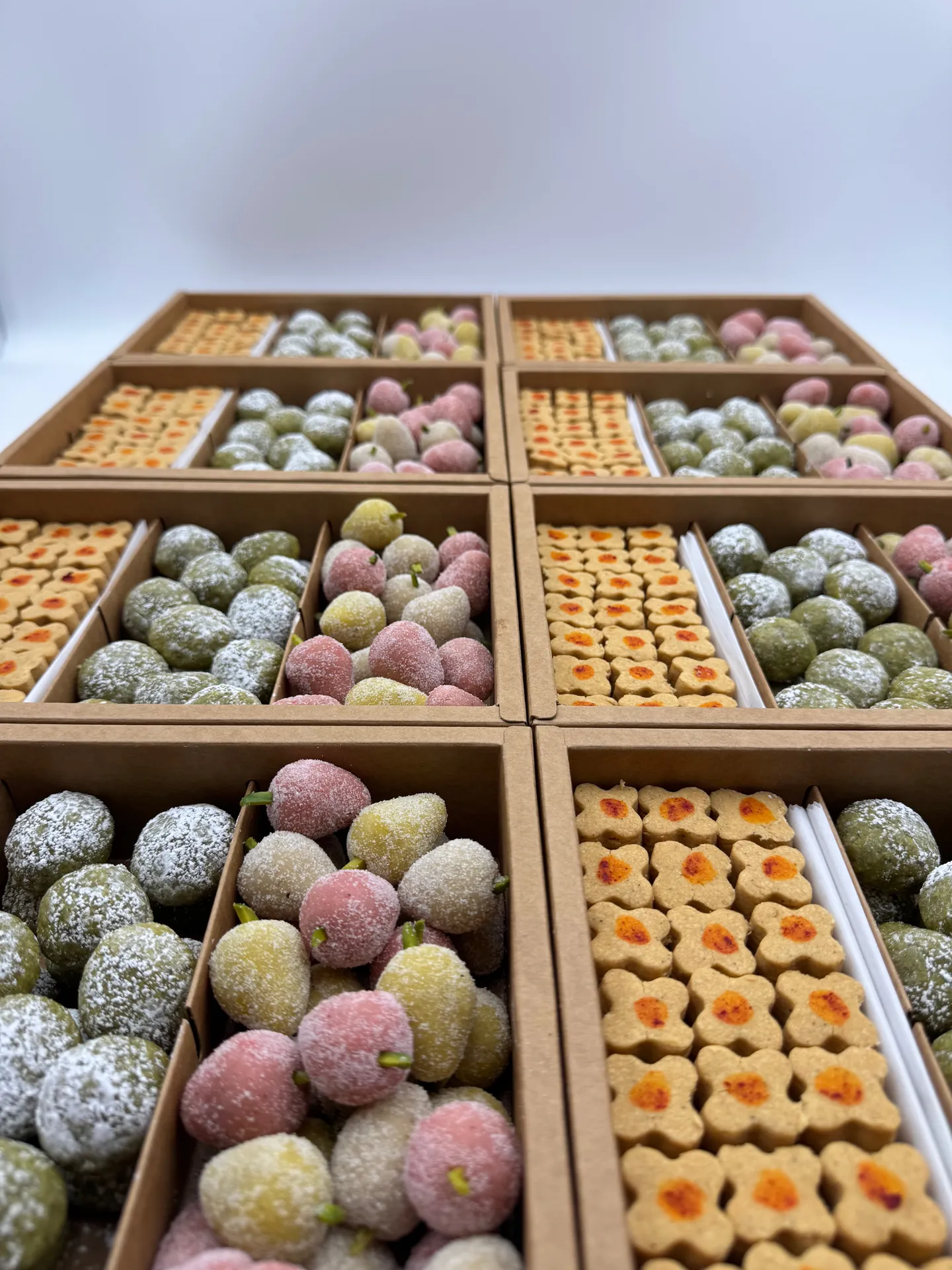 Top view of a custom Persian pastry box with toot, pistachio bites, and chickpea cookies